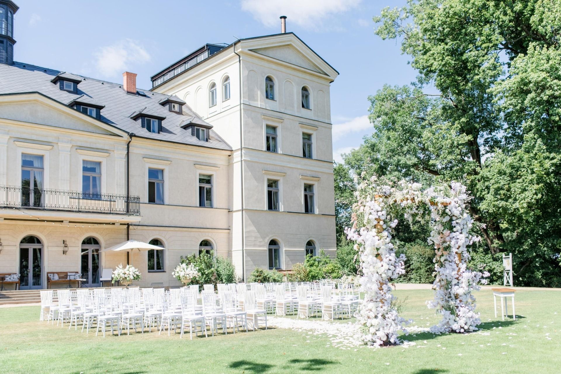 Svatební obřad s květinovou branou před zámkem